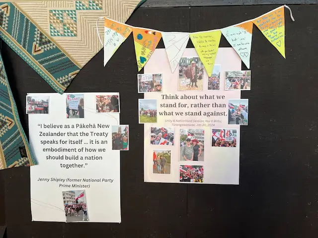 Two posters on a dark wall; one features a quote by Jenny Shipley, and the other encourages reflection on the Treaty, adorned with colorful bunting.